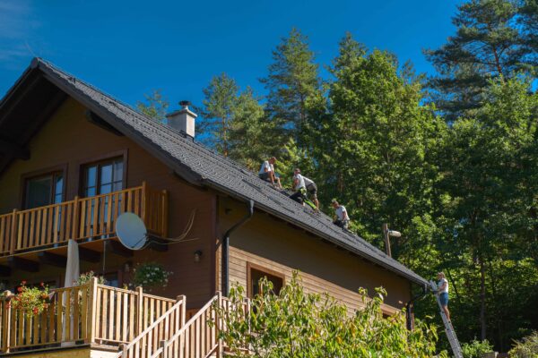 Travailleurs sur un toit d'une maison en bois.